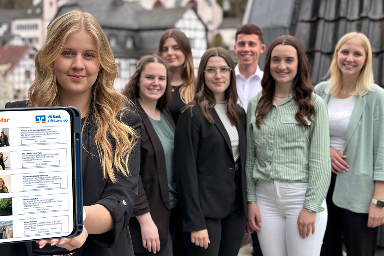 Azubis stehen zusammen wähend ein Azubi ein Tablet in die Kamera hält