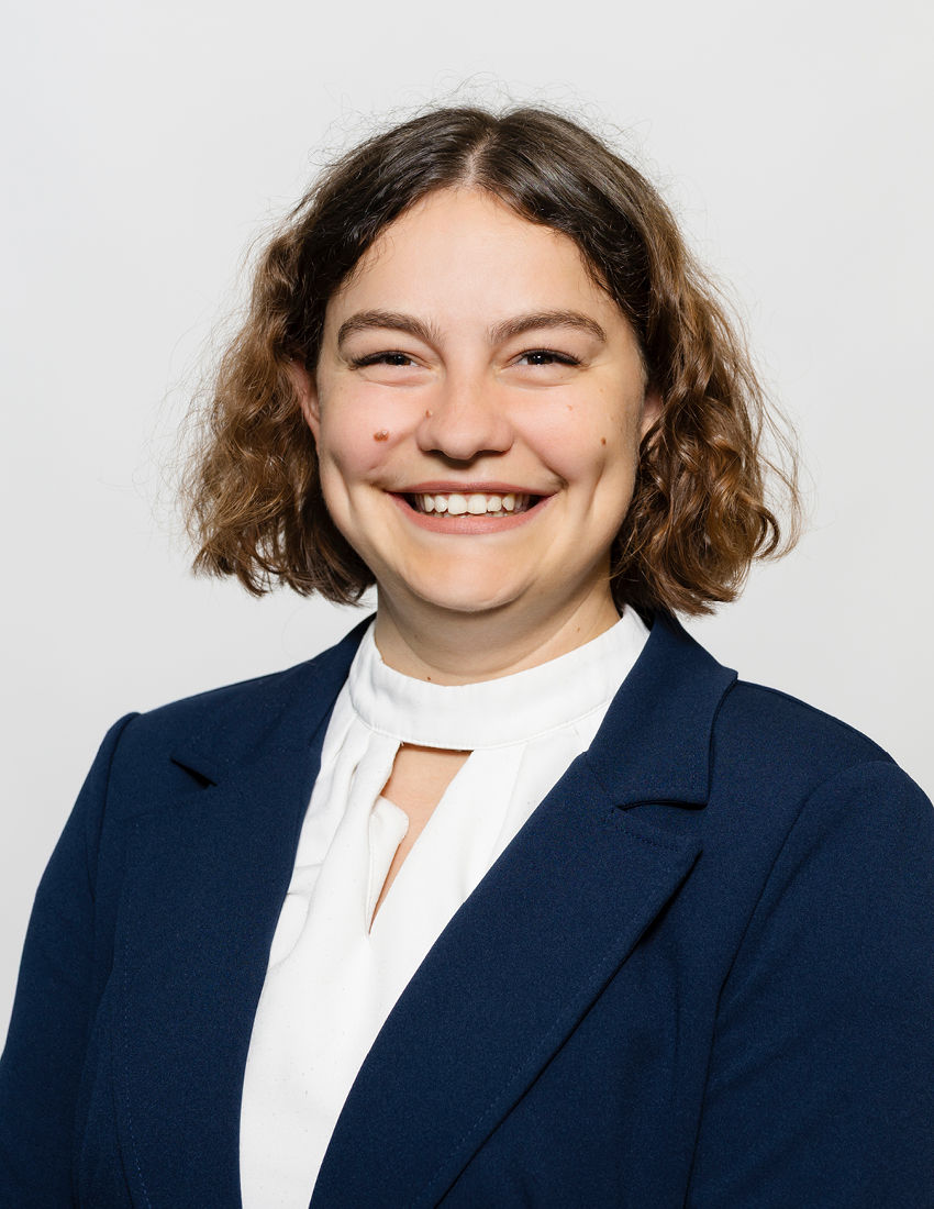 Foto unserer Vermögensberaterin Katja Schlennert vor einem grauen Hintergrund in einem dunkelblauen Blazer und weißer Bluse