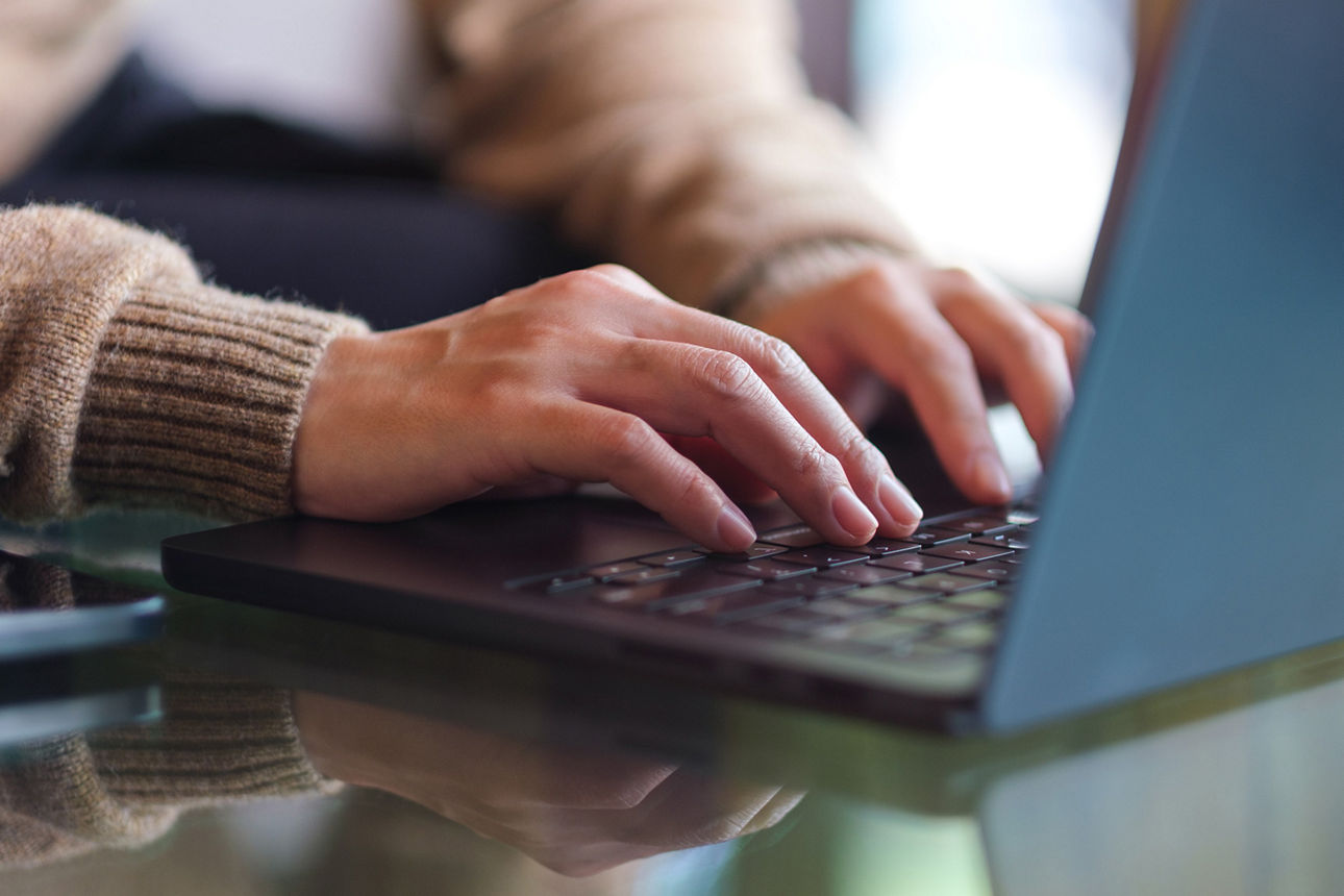 Männliche Hände tippen auf die Tastatur eine Laptops
