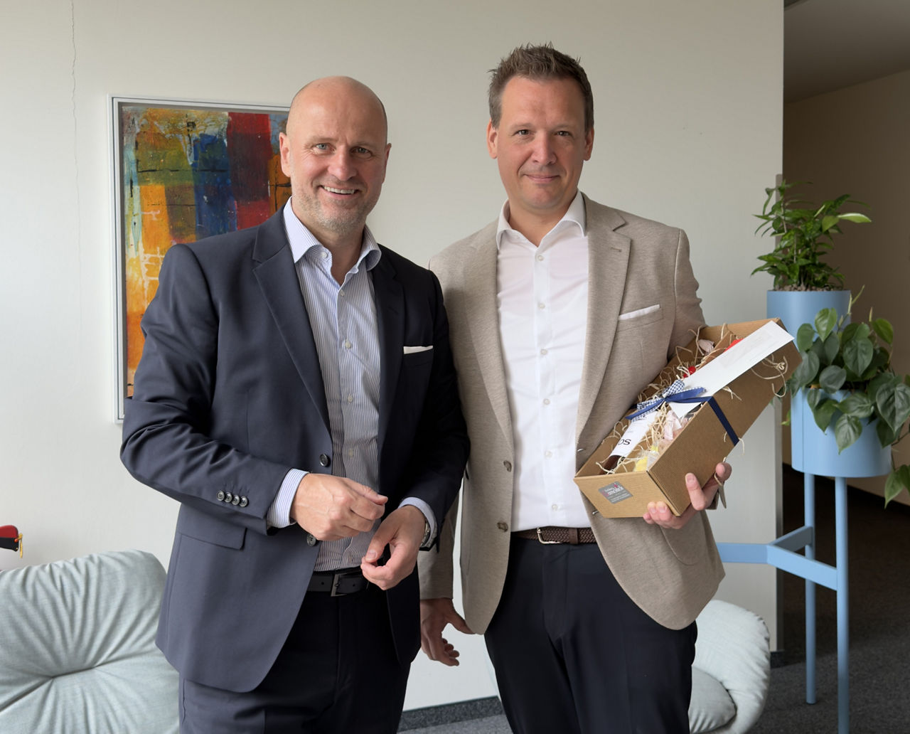 Dietmar Dertwinkel (Vorstandsmitglied, links) gratuliert Christoph Roß (Bereichsdirektor Business Development, rechts).