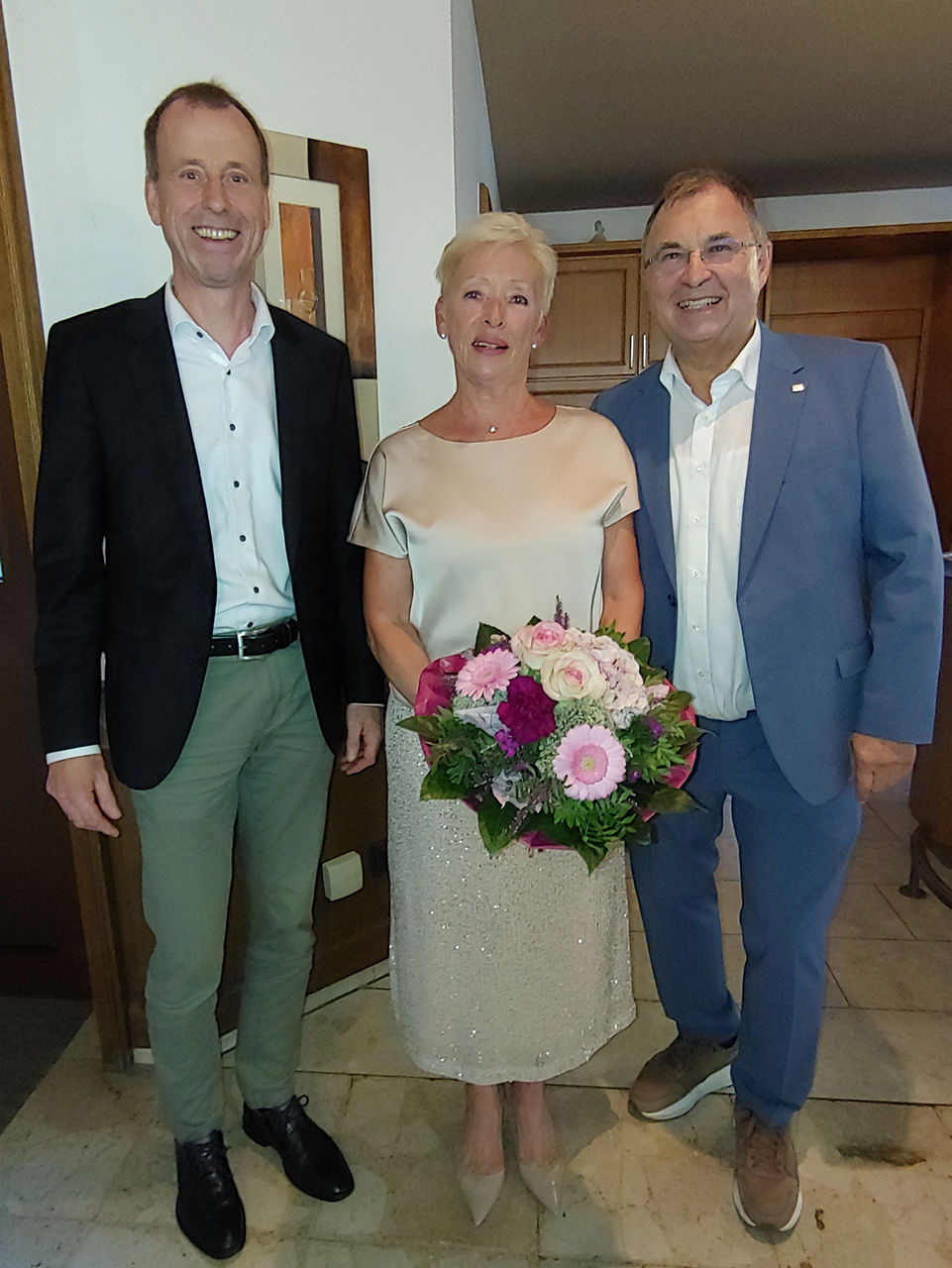 Die Vorstandsmitglieder Friedhelm Beuse (links) und Thomas Schmidt (rechts) danken Annegret Bockey (Mitte).