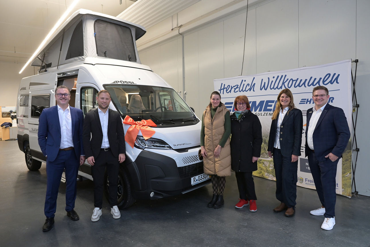 6 Personen stehen vor einem gewonnnen Wohnmobil