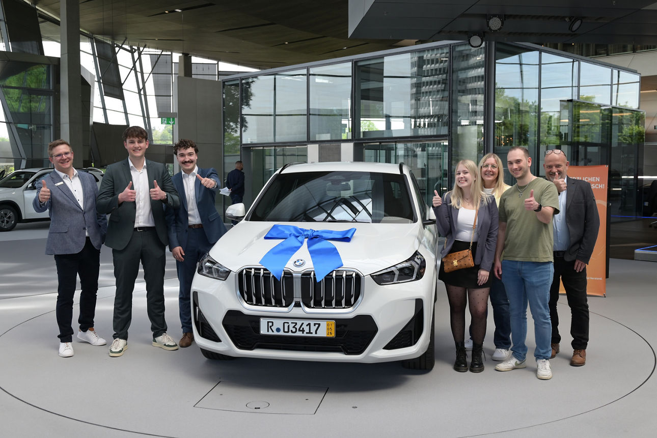 Gewinnübergabe eines BMW X1 mit Gewinnerin und ihrer Familie sowie Mitarbeitende der VR Bank Vilshofen Pocking und des Gewinnsparverein