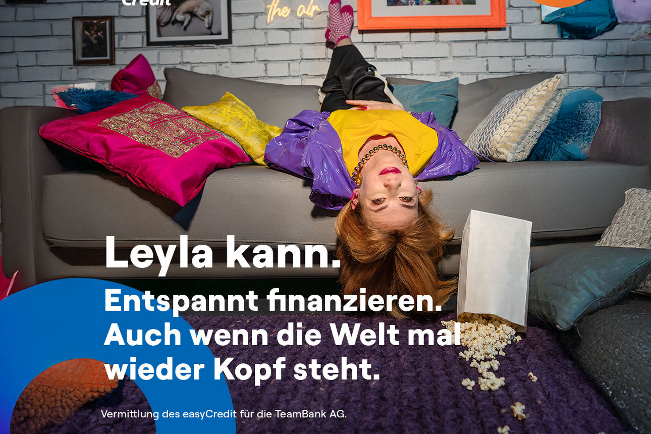 easyCredit - Dame entspannt auf Sofa wegen finanzieller Freiheit