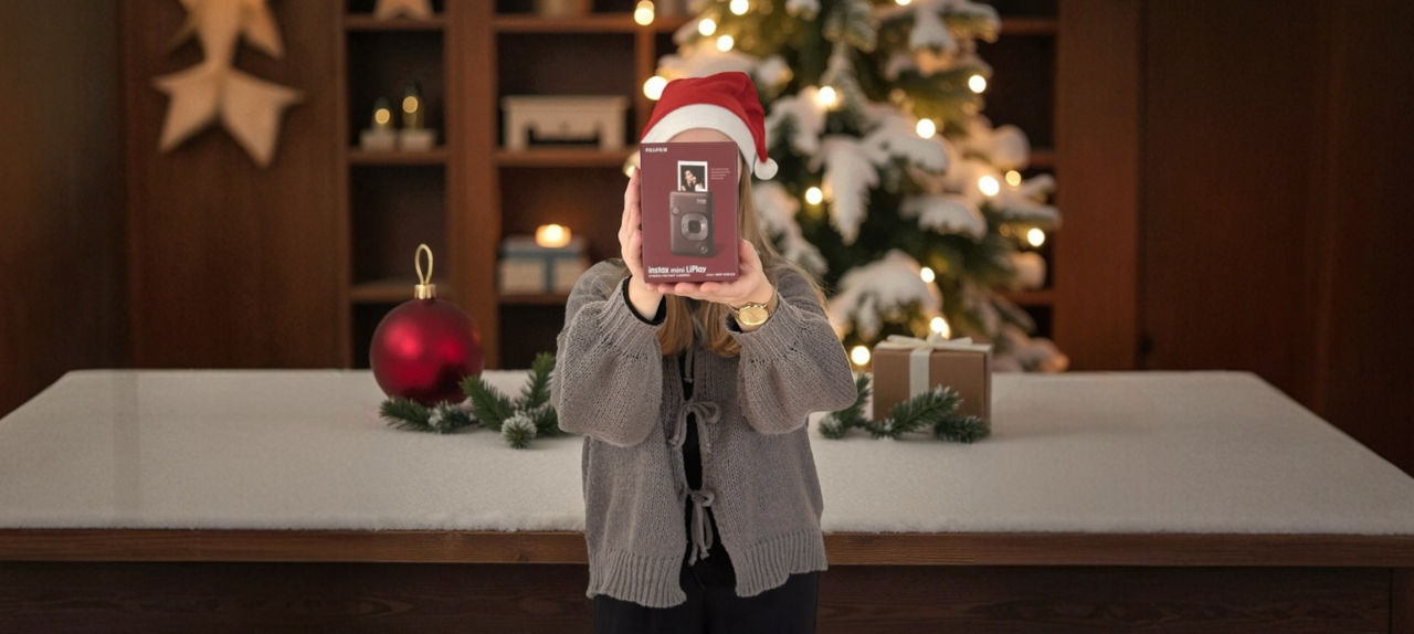 Eine Frau mit Weihnachtsmütze hält den Kamera Preis vor Ihr Gesicht