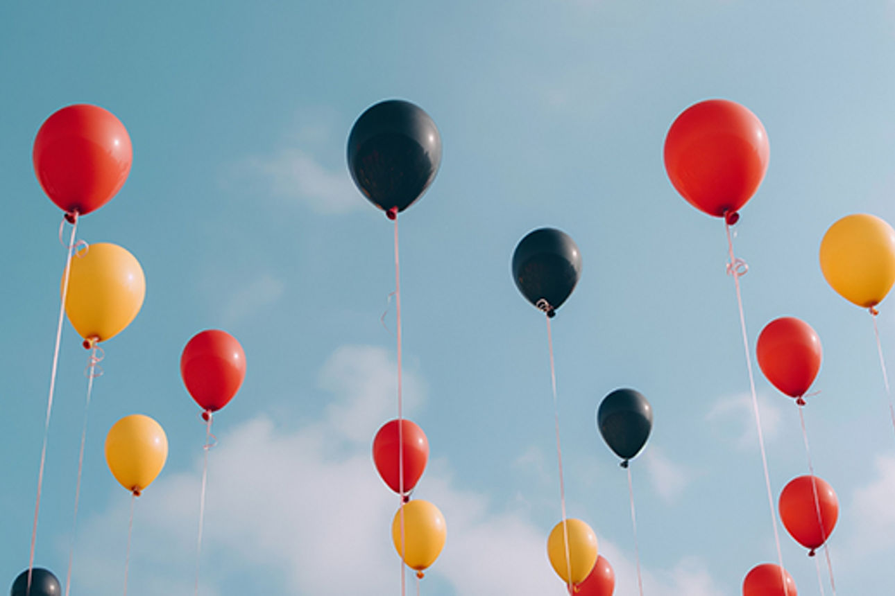 Zur Feier der Tag der deutschen Einheit Luftballons in schwarz rot gold vor blauem Himmel