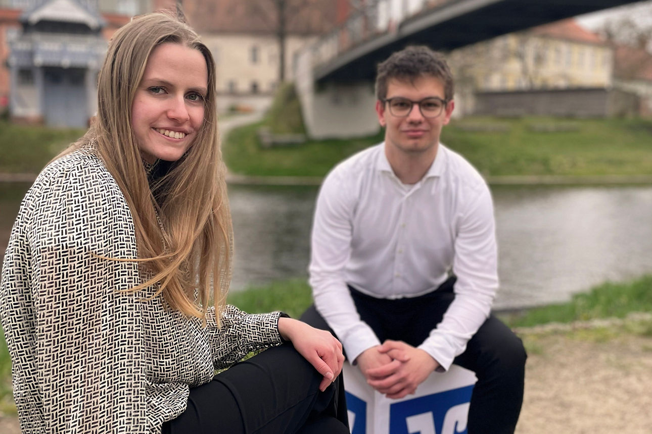 Zwei Auszubildende sitzen auf VR Würfeln an der Havel