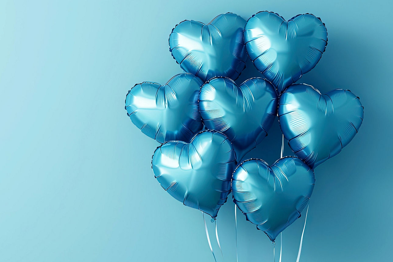 Blue heart-shaped balloons on a blue background. Foil balloons - love concept. Balloons. Seven blue foil balloons in the shape of a heart on a blue background. Symbol of love. Festive celebration. Party decoration for Valentine's Day. Birthday.
