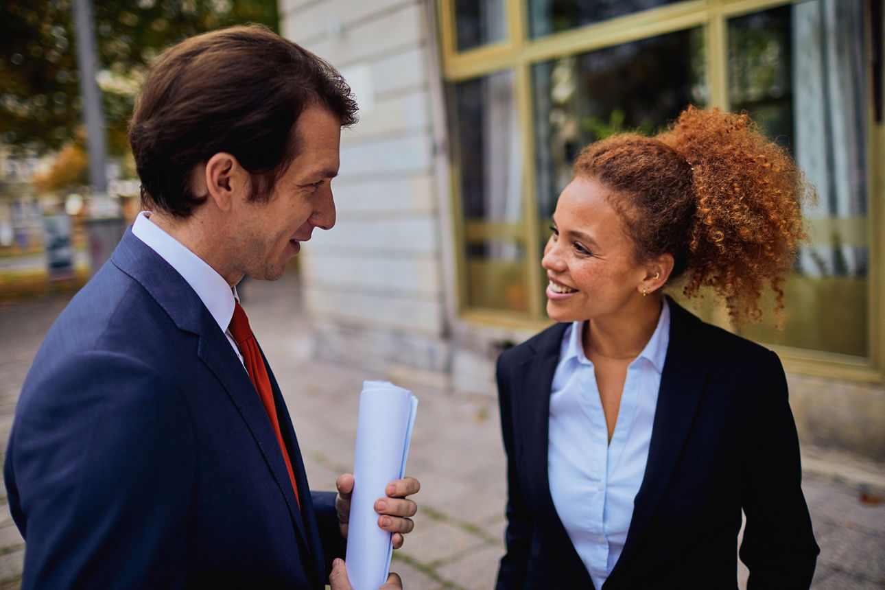 Mann und Frau stehen sich gegenüber und lächeln sich an