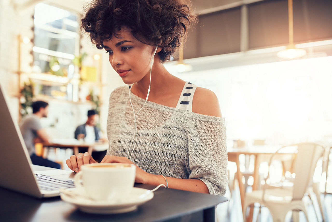 Frau sitzt am Laptop im Café