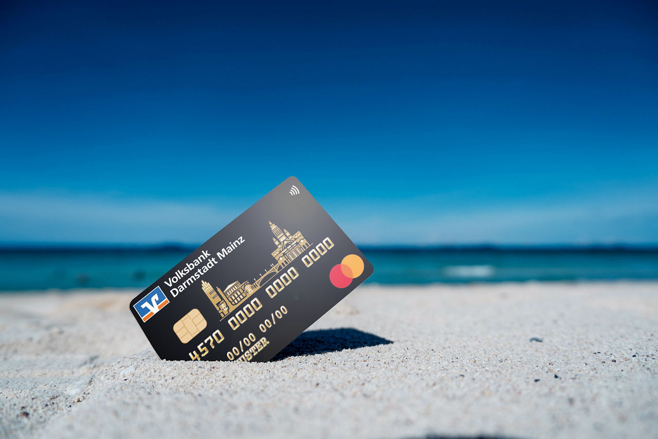 GoldCard steckt im Sand am Meer