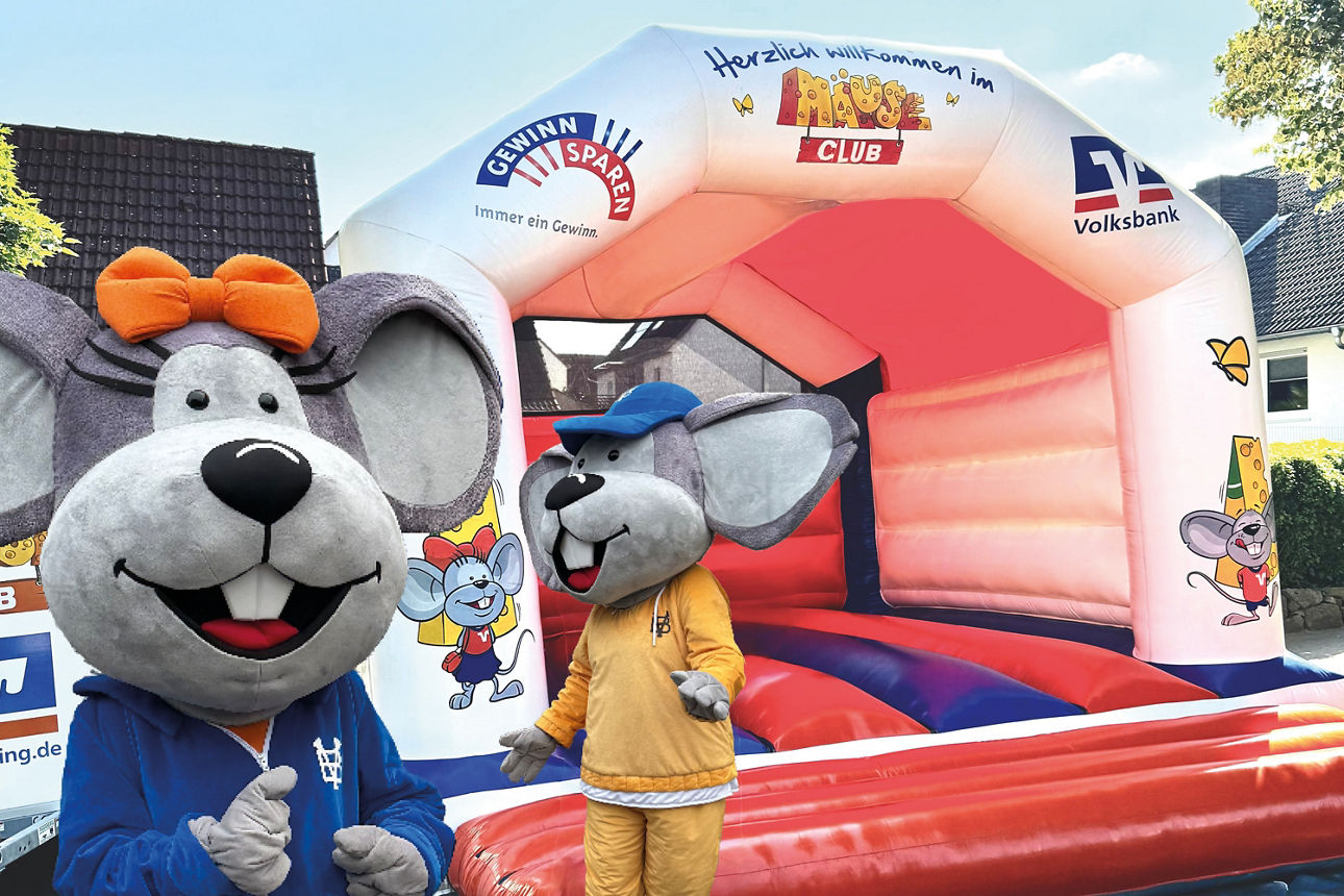 Hanni und Manni stehen vor einer Hüpfburg