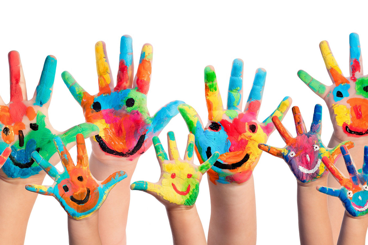 Bunte Kinderhände mit einem aufgemalten Gesicht