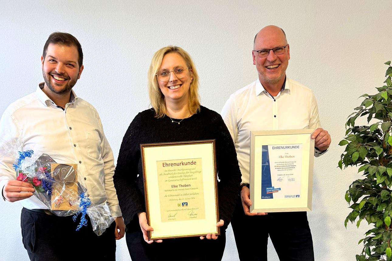 Drei Personen in Businesskleidung stehen neben grünen Pflanzen, Gruppenfoto im Innenraum