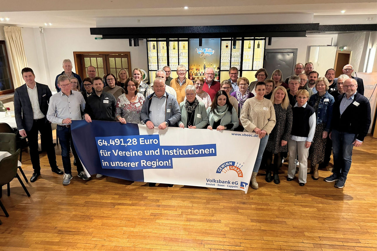 Eine Gruppe von Menschen steht vor einer Bar und hält ein Plakat mit Informationen zu Spenden.