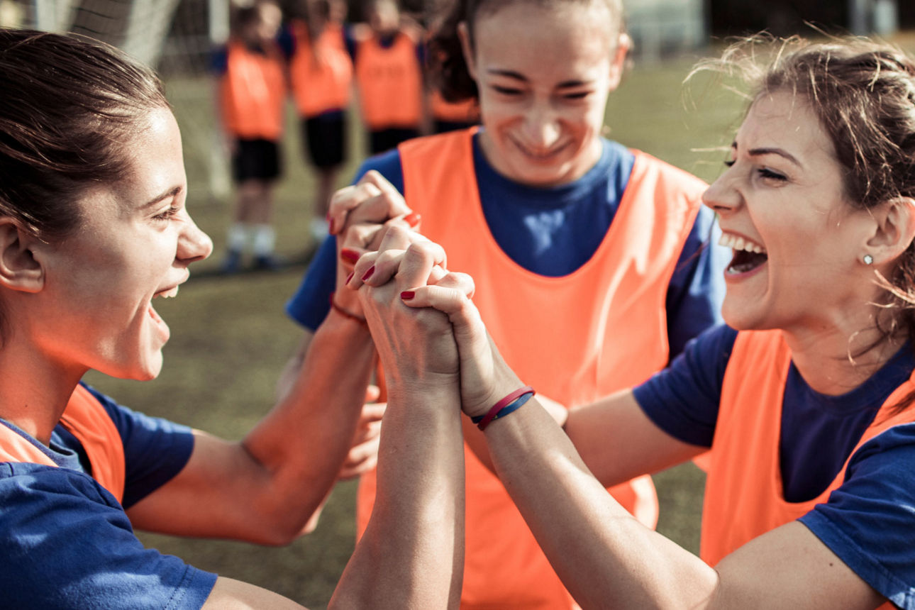 Jugendliche feiern gemeinsam beim Teamsport auf dem Fußballfeld.