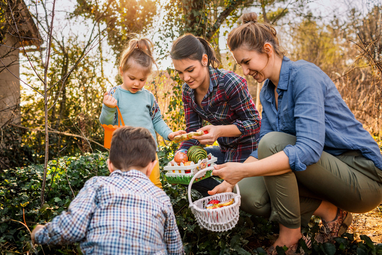 Familie sucht Ostereier im Garten im Morgenlicht