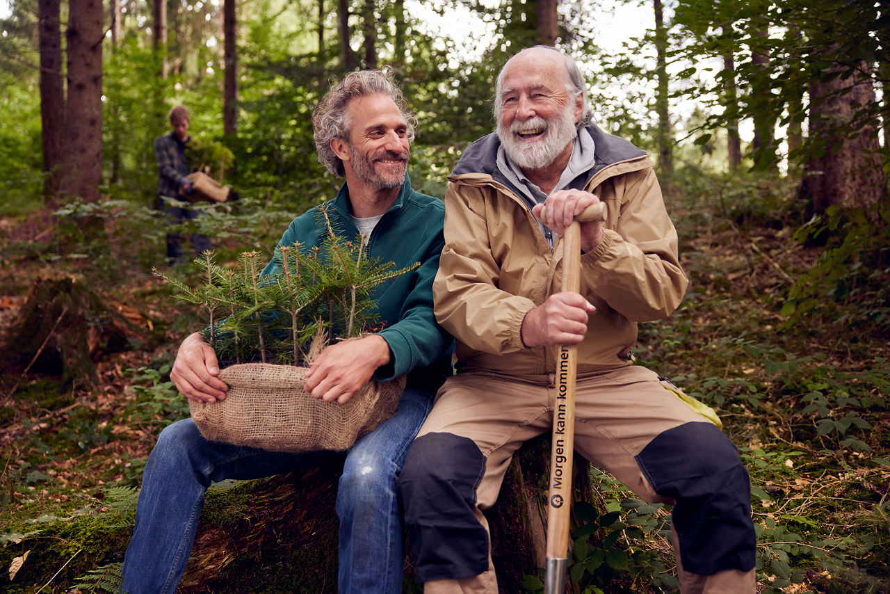Zwei Männer mit Bart sitzen im Wald mit Sprößlingen