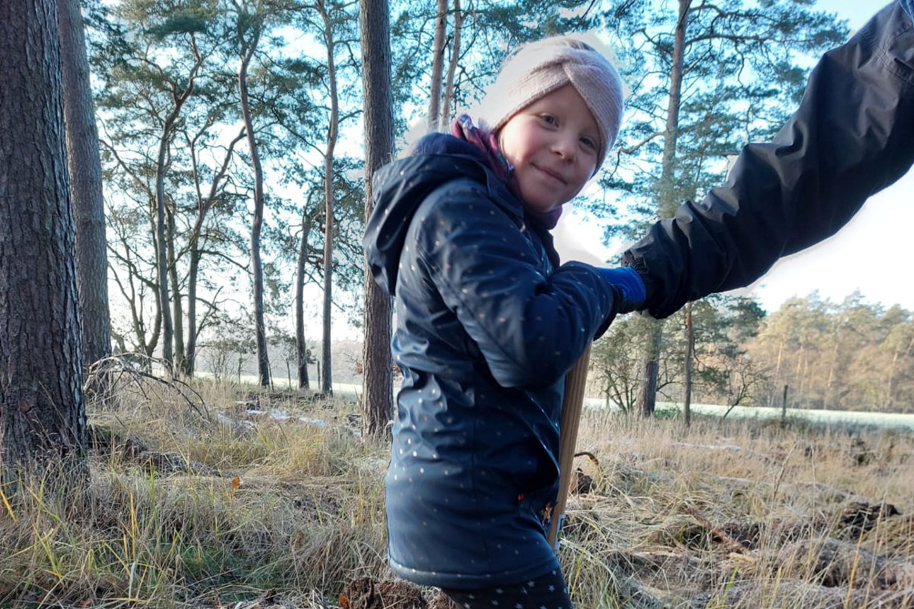 Ein Kind steht auf einem Spaten.