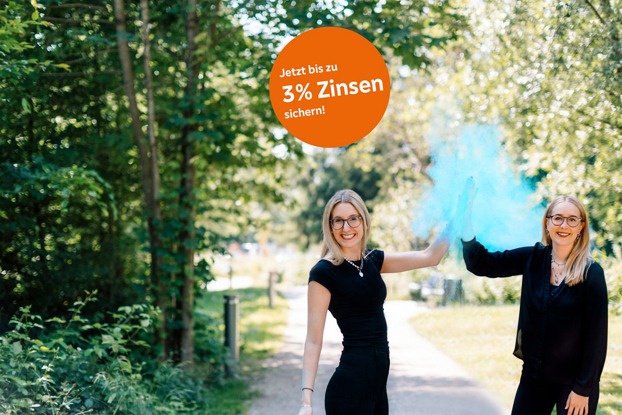 Zwei Frauen klatschen in die Hände und blauer Staub schwebt um sie herum.