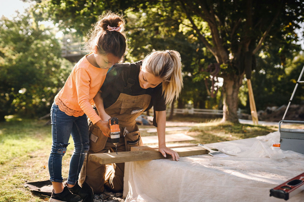 Mutter und Kind bauen Baumhaus