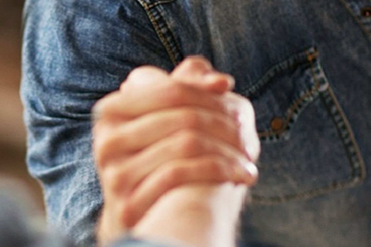  Ein Mann und eine Frau umarmen sich innig an einem Sandstrand