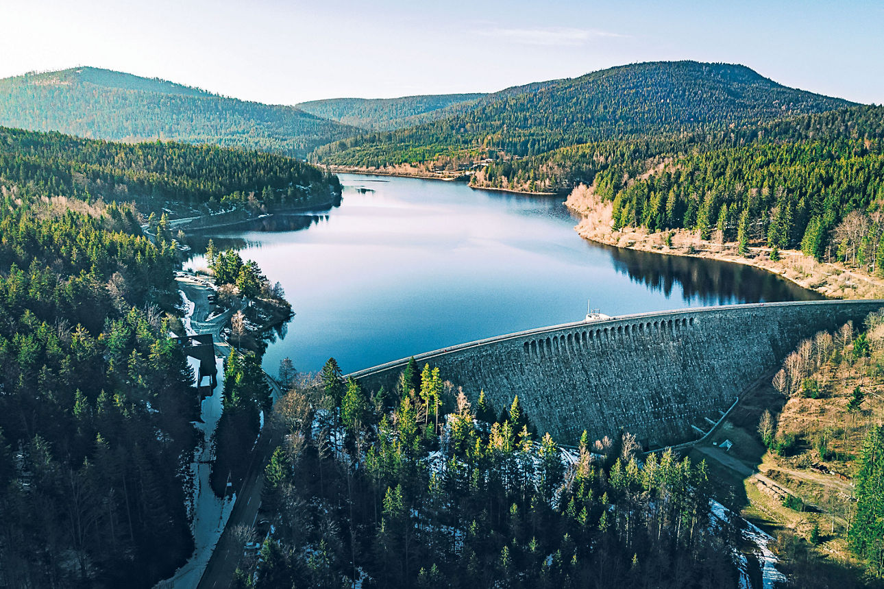 Ein Staudamm, um den herum sich Wälder und sanfte Hügel befinden