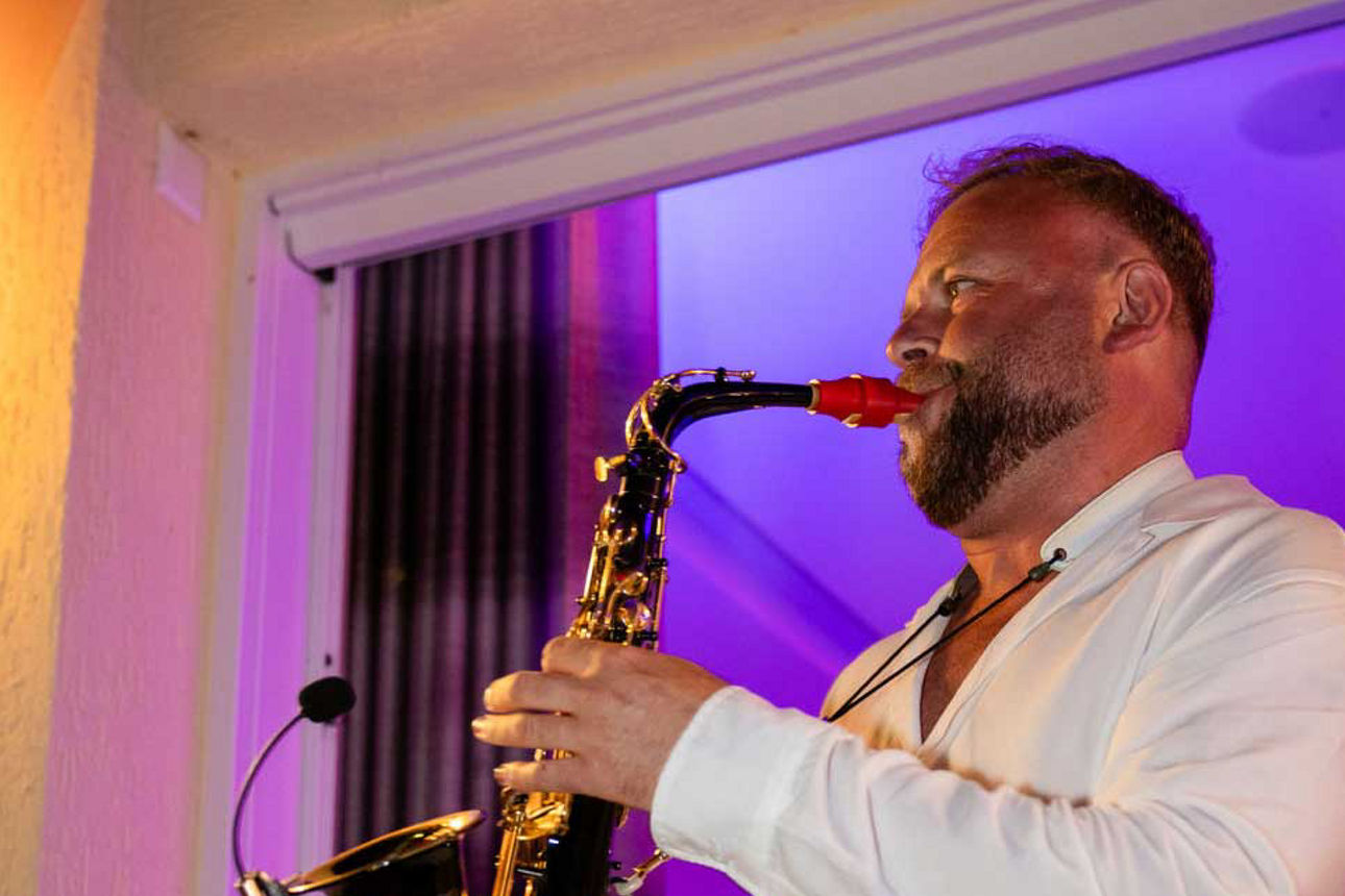 Person die auf einer Bühne Saxophone spielt.