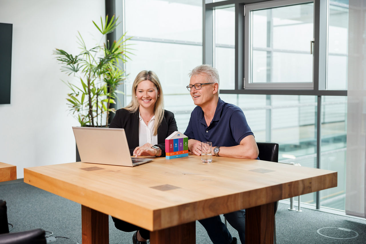 Beraterin schaut mit ihrem Kunden in den Laptop
