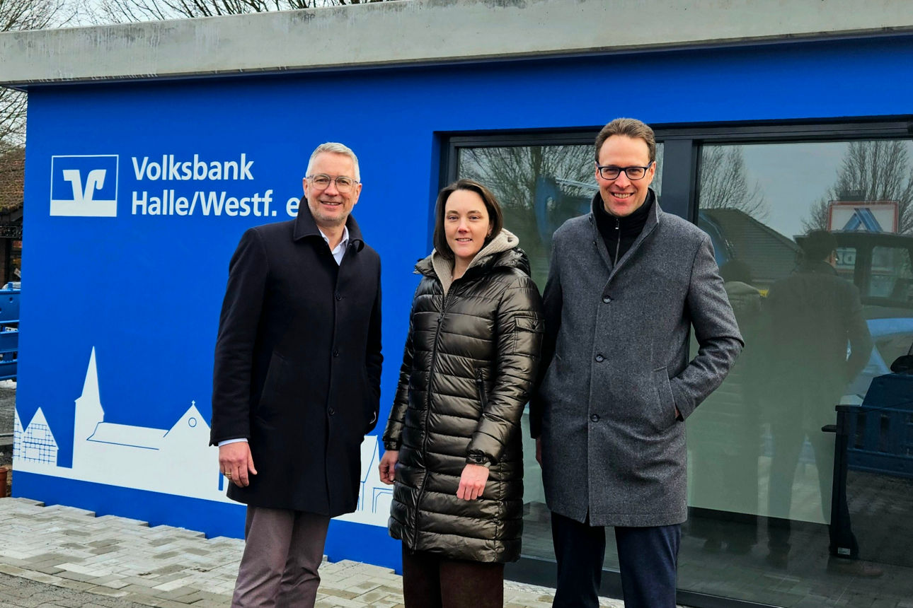Außenansicht mit dem Branding der Volksbank Halle/Westf. auf einer hellblauen modularen Gebäudefassade.