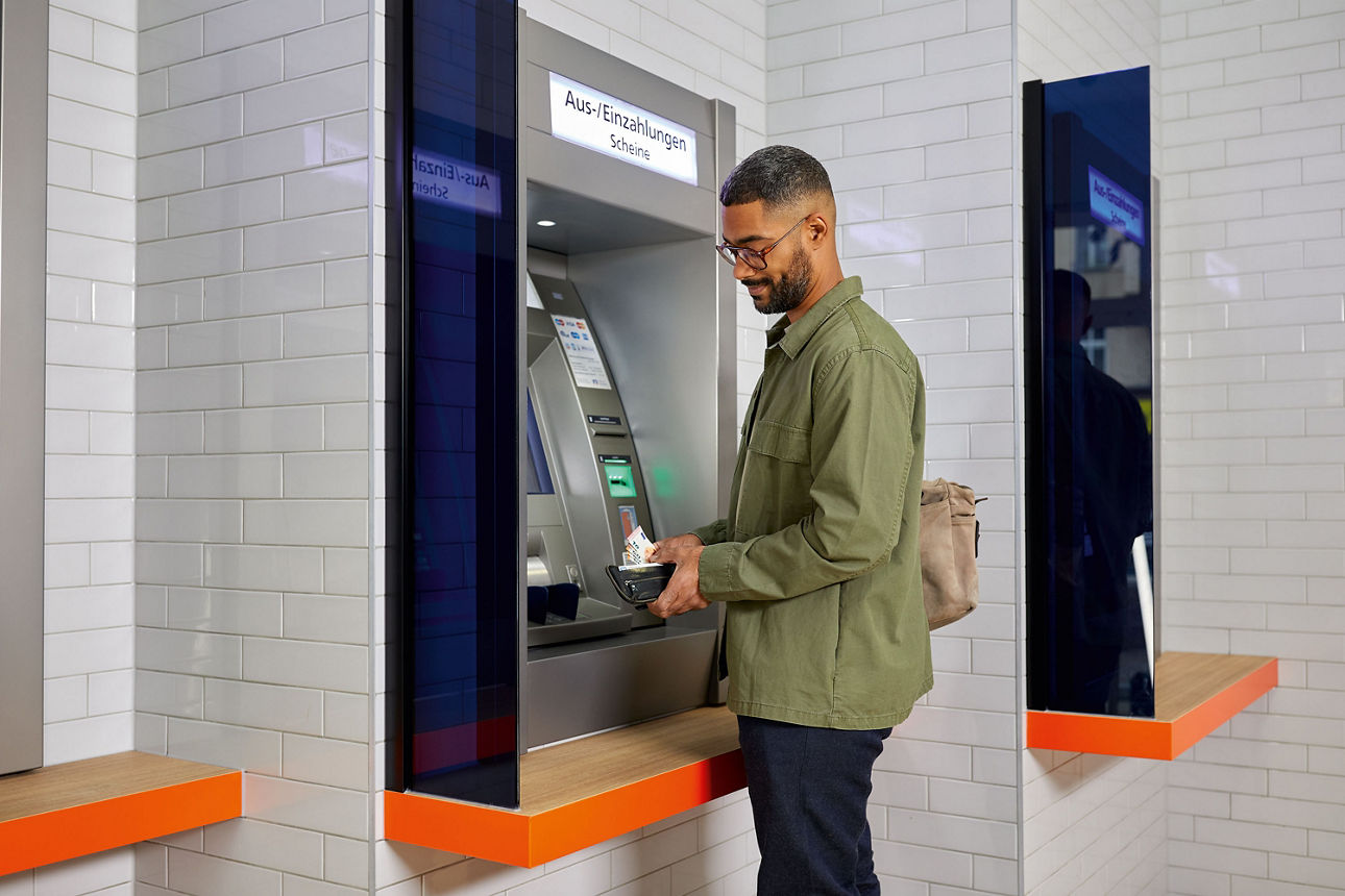 Mann am Geldautomat einer Bank