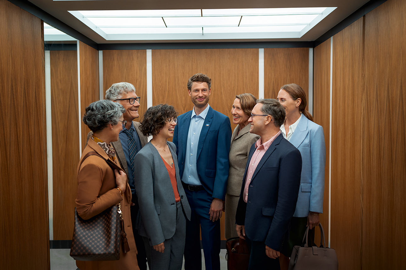 Geschäftsleute stehen im Kreis um einen Berater und schauen in an