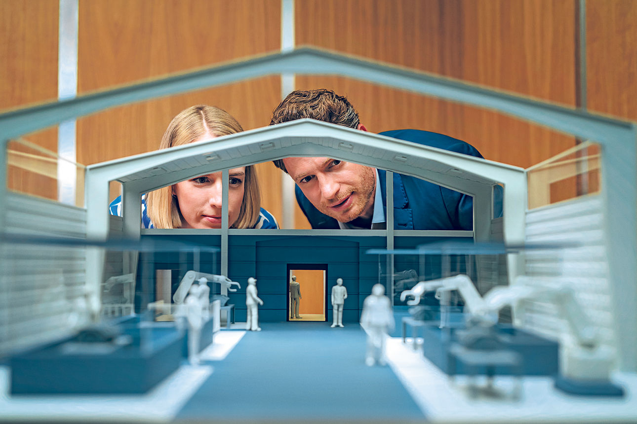 Zwei Personen schauen auf ein Firmenmodell