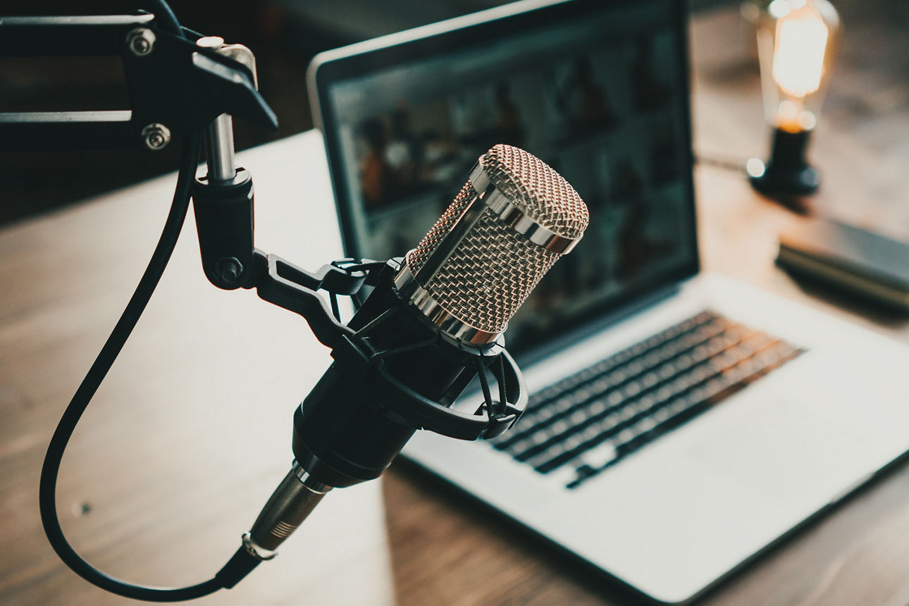 Mikrofon und Laptop im Hintergrund.
