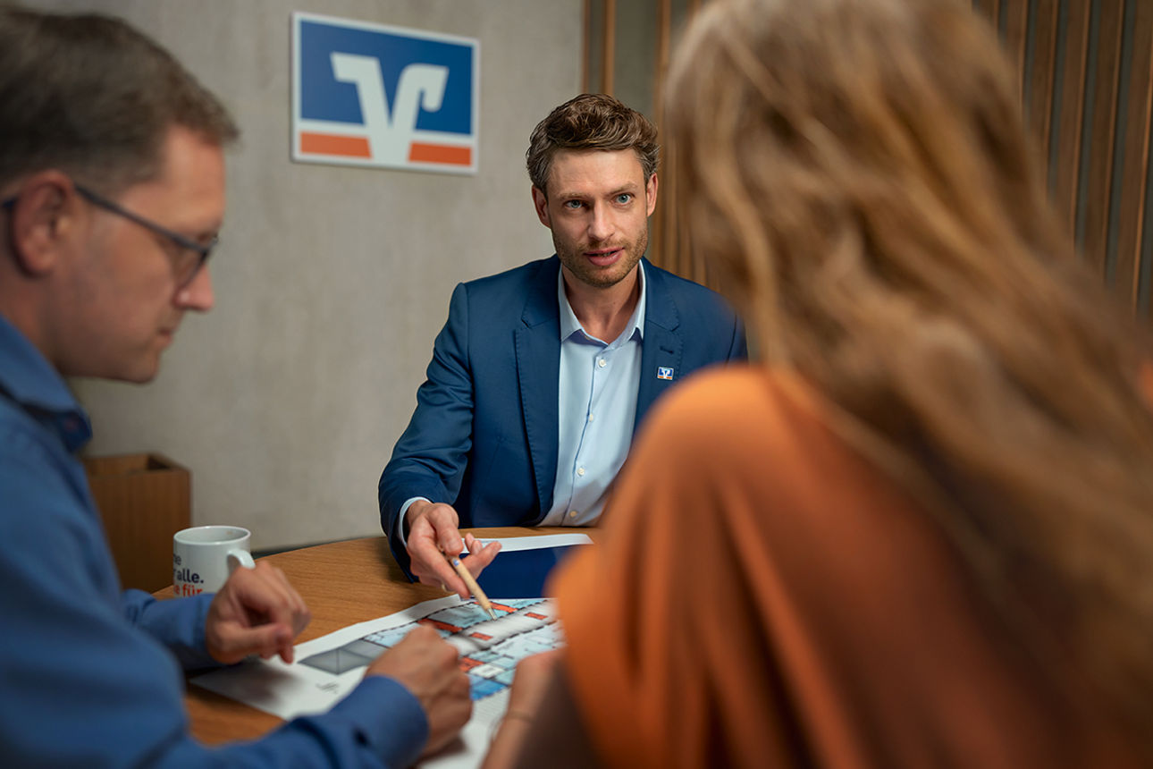 Drei Personen sitzen in einem Beratungsgespräch. 