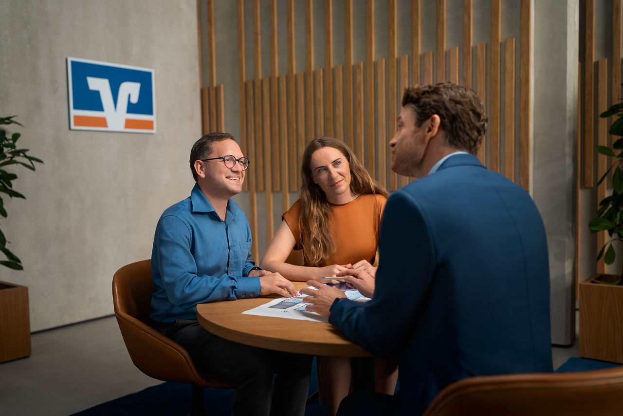 Zwei Männer und eine Frau sitzen an einem Tisch