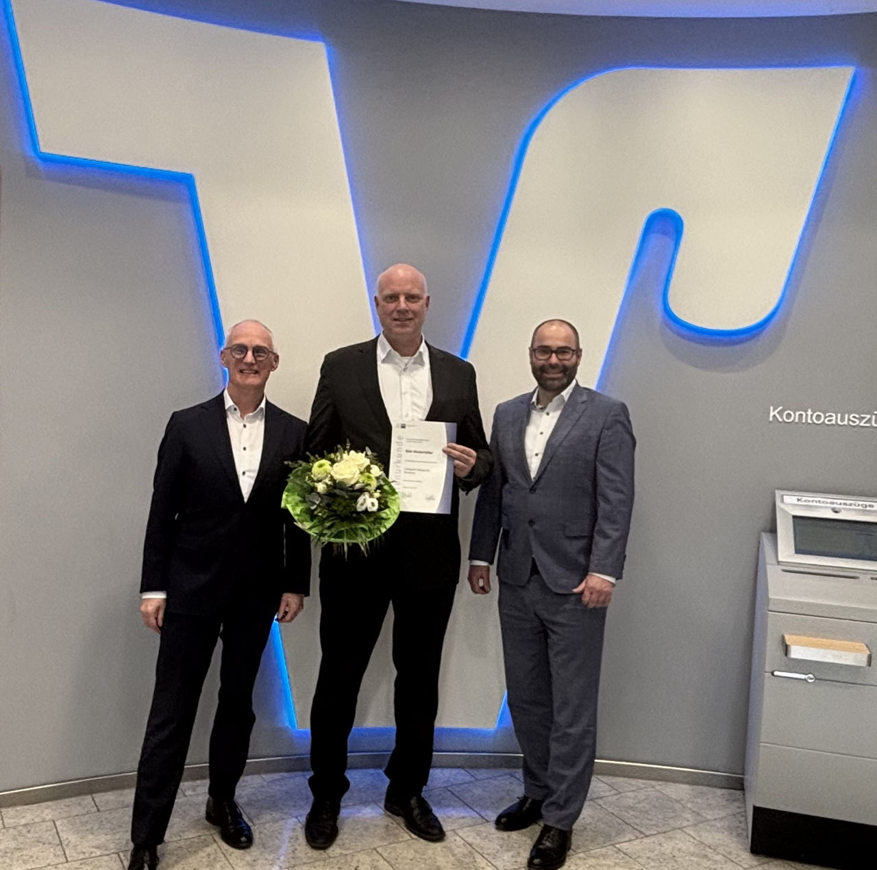 Drei Herren in Geschäftskleidung posieren in Innenräumen