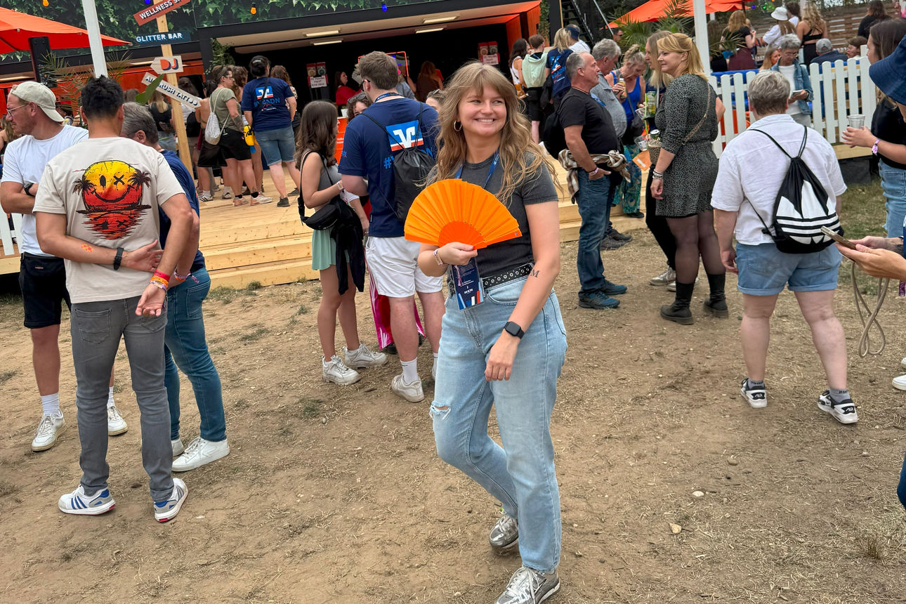Genießen Sie die lebhafte Atmosphäre des Festivals, komplett mit einem Hauch von Flair und einem erfrischenden Orangenfächer