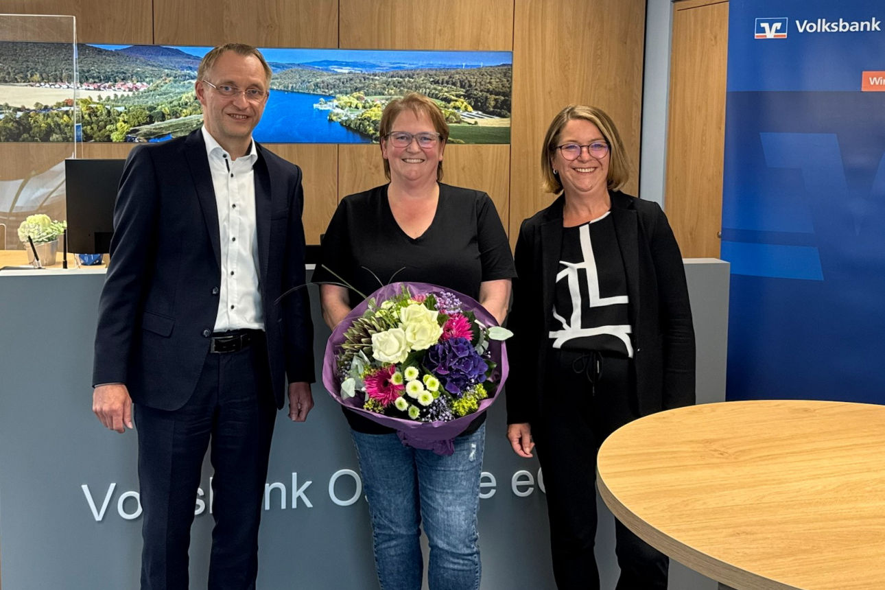 Ein feierlicher Moment, festgehalten in einer professionellen Umgebung.  Ein Blumenstrauß wird überreicht, als Zeichen für ei