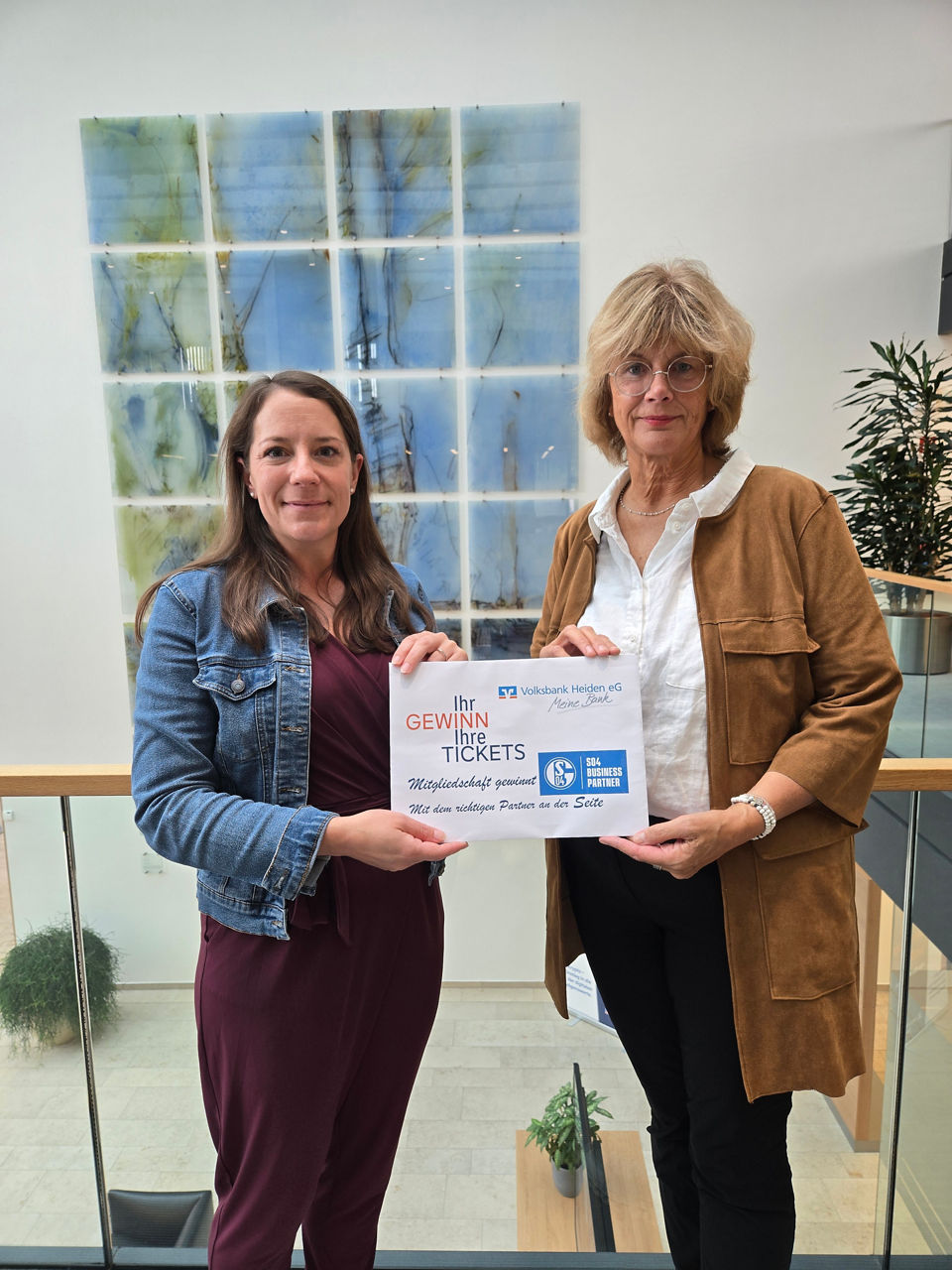 Zwei lächelnde Frauen halten ein „Danke“-Schild