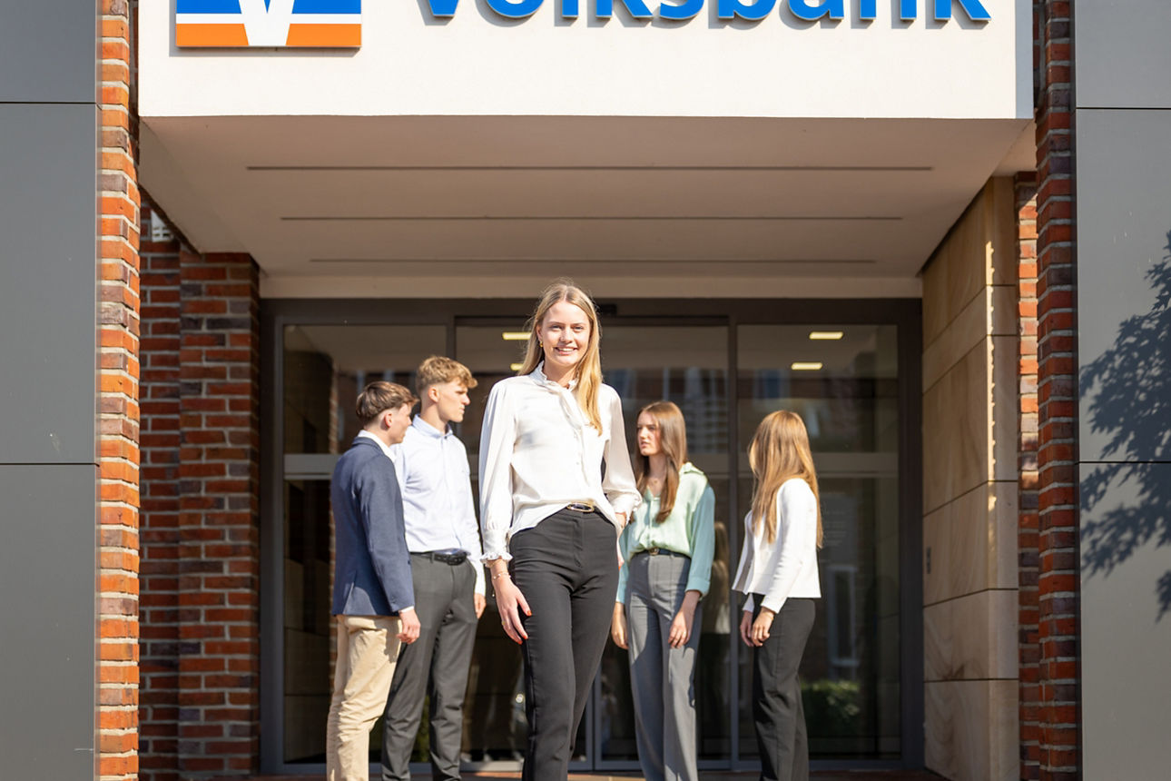 Junge Leute stehen vor einer Volksbank