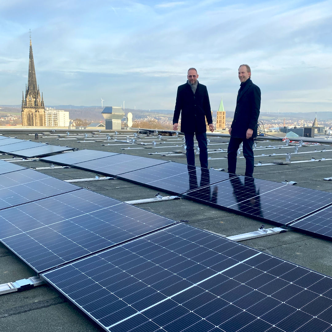 Nachhaltigskeitsmanager Jan Ackerhans und Gebäudemanagement auf PV-Anlage