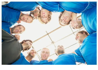 Drei lachende Menschen stehen vor einer blauen Wand mit dem Schriftzug „Wir sind meine Bank.”