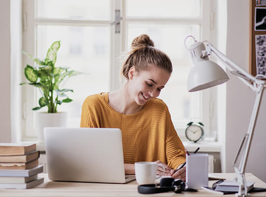 Eine junge Frau arbeitet an ihrem Laptop