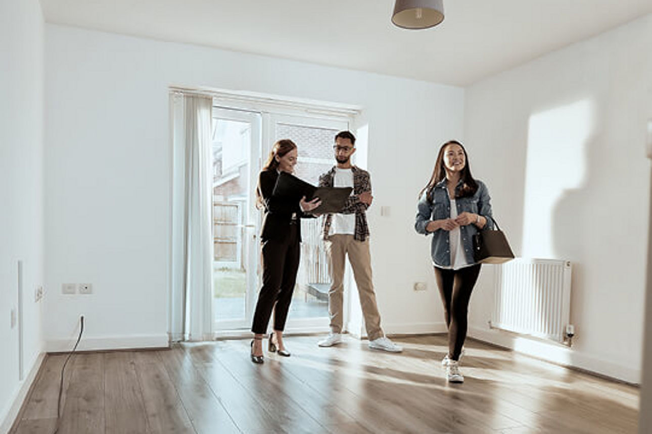 Eine Paar besichtigt eine Wohnung mit einer Maklerin
