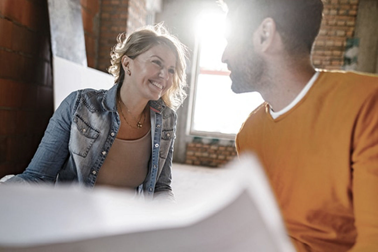 Ein Mann und eine Frau besprechen Baupläne
