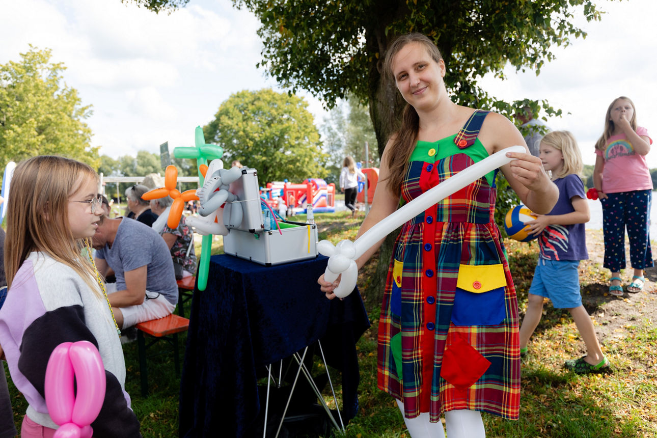 Junge Frau die für umstehende Kinder Ballons falten