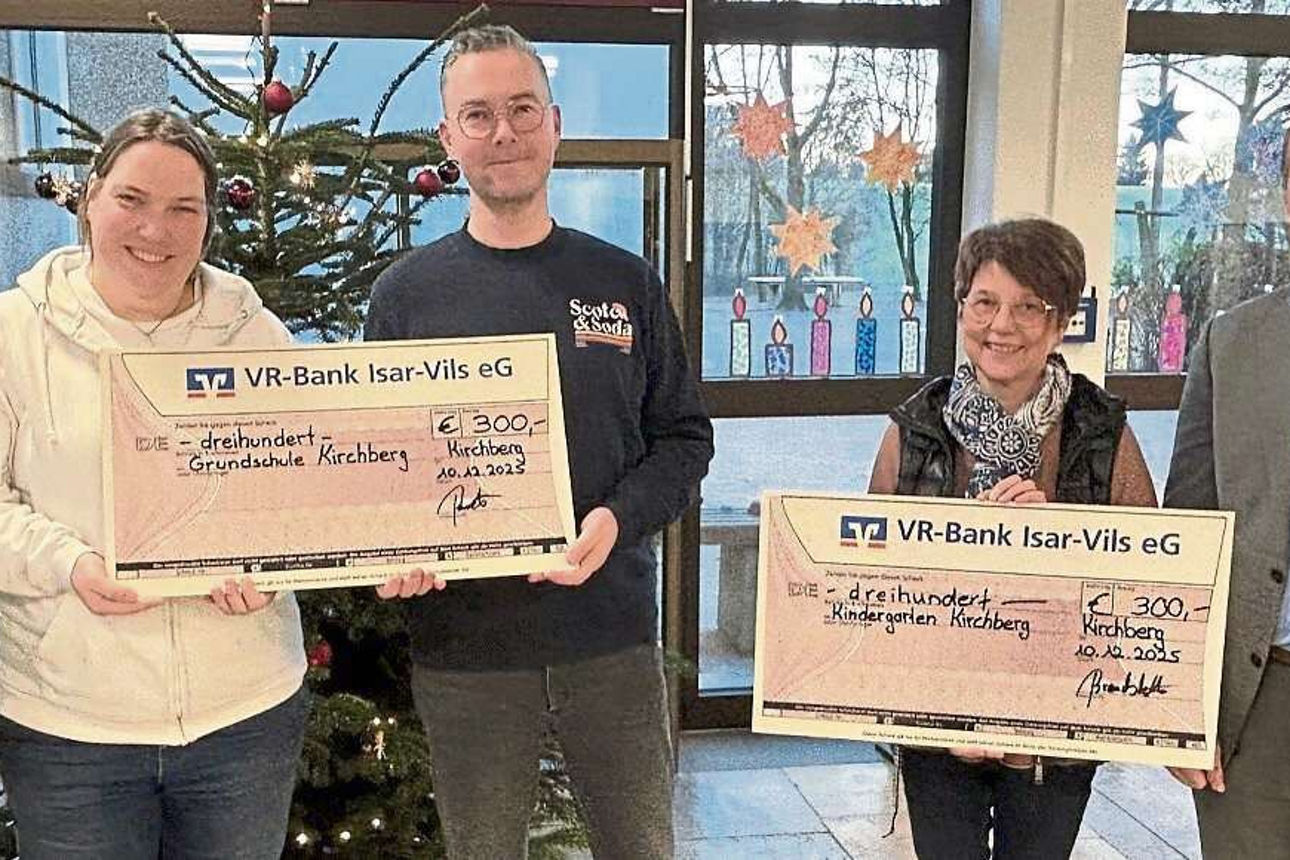 Drei Männer und zwei Frauen mit Spendenschecks in der Hand lächeln in die Kamera.