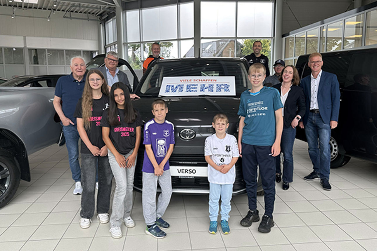 Eine Gruppe fröhlicher Leute in einem Autohaus