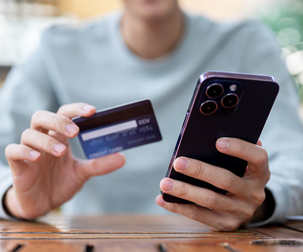 Mann mit Kreditkarte und Handy in der Hand